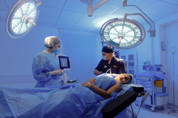 A male and a woman surgeon looking at vitals on the screen making sure everything is set for surgery