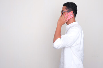 Side view of a man answering a phone call
