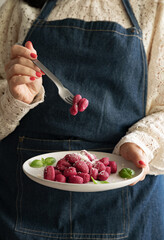Italian gnocchi beetroot . Traditional Italian food in a bowl is held by a woman in an apron. Handmade potato balls with parmesan and beets. Food for vegetarians and lovers of Italian typical cuisine 