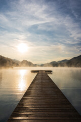 Ein Bootssteg bei Sonnenaufgang am Fuschelsee in Österreich. Herbst Hintergrund, Natur. © Sonja Rachbauer