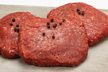 steaks hachés de boeuf crus, en gros plan, isolé sur un fond blanc