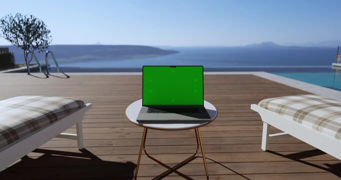 Swimming pool with beach lounge chair sun bed on the wooden deck and sea view. Laptop place on table, Green screen display, Close up monitor of notebook with mock up