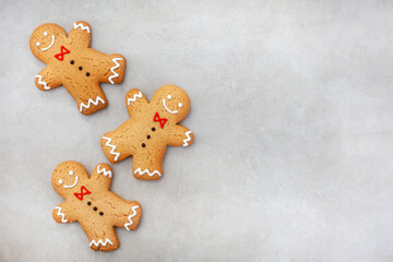 Three gingerbread men on mottled grey surface