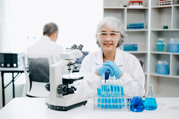 Fototapeta premium Scientists conducting research investigations in a medical laboratory, a researcher in the foreground is using a microscope in laboratory for medicine. .