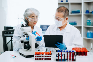 Scientists conducting research investigations in a medical laboratory, a researcher in the foreground is using a microscope in laboratory for medicine.  .