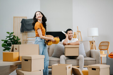 Happy asian young attractive couple man and woman with big boxes moving into a new house, new apartment for couple the new home, Moving house. on sofa..