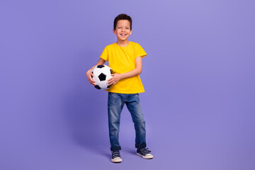 Full length photo of nice young pupil boy hold soccer ball player dressed yellow garment isolated...