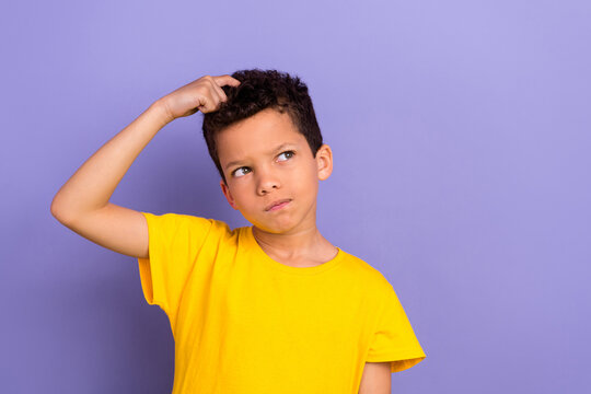 Photo of minded uncertain unsure boy arm touch hair look empty space hmm creative idea solution isolated on purple color background