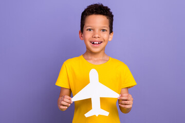 Photo of excited cheerful boy wear trendy clothes hand hold paper plane recommend travel agency...