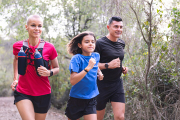portrait of a family practicing trail running in the forest, concept of sport in nature and healthy family lifestyle