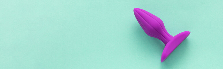 Purple Anal Plug on a green background. Sex toys. Copy space for text. banner