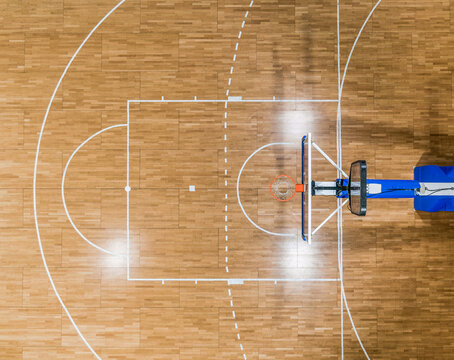 Top view of a basketball hoop and the restricted area (the key) with a foul line (free throw lane) on a parquet basketball court
