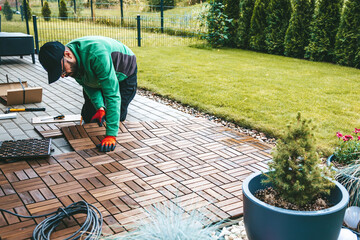 A man worker laying wooden flooring on the terrace