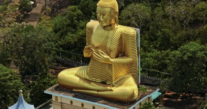 Dambulla Sri Lanka Aerial v6 drone fly around Uyanwatta Sri Meadankaraaramaya Buddhist temple in Giriulla capturing giant golden Buddha statue sit on building top - Shot with Mavic 3 Cine - April 2023