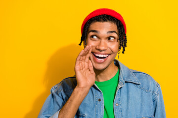 Photo of positive guy wear jeans shirt arm touch face space share special proposition look empty space isolated on yellow color background