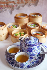 Closeup of Hot Chinese Oolong Tea Set with Blurry Assorted Dim Sum Dishes