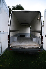 Empty old dirty refrigerated truck inside, with cargo area lighting. Interior of van for transporting frozen food