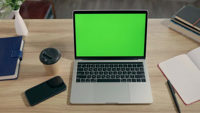 Laptop With Green Mock-up Screen On Desktop In Cozy Home Office. Chroma Key on Notebook Display