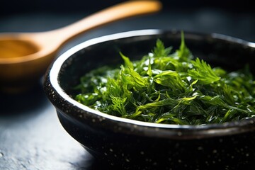 close-up of a vibrant green seaweed salad in a matte black bowl