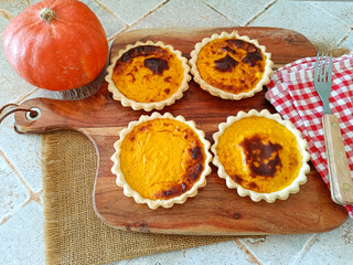plusieurs tartelettes au potiron sur une planche à découper	