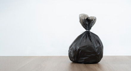 Close up garbage bag on wooden floor with white background. - obrazy, fototapety, plakaty