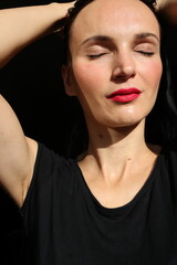A very delicate and well-groomed female face in the sun. - obrazy, fototapety, plakaty