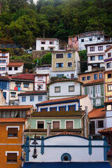 Fototapeta na wymiar Colorful, stacked houses on the mountainside in Cudillero, Spain, a charming coastal town