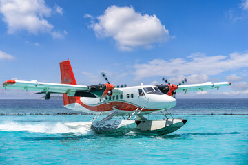 Exotic seascape seaplane on Maldives sea landing. Vacation or holiday luxury travel transportation in tropical popular destinations. Airplane flight and landing on calm ocean bay