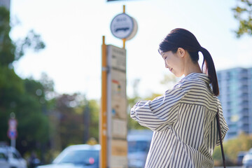 バス停でバスを待つ日本人の女性 - obrazy, fototapety, plakaty