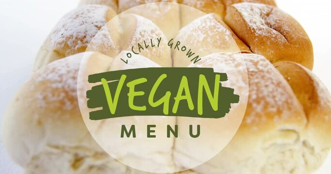Animation of locally grown vegan menu text banner against close up of fresh bread