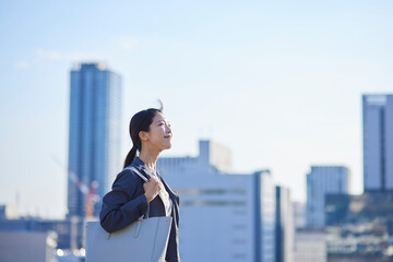 ビジネス街にて遠くを見つめる日本人ビジネスウーマン