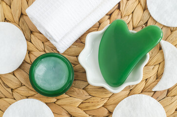 Green gua sha massage stone. Traditional chinese medicine beauty tool for anti aging treatment. Top view.