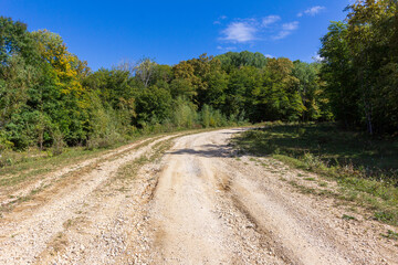 Late autumn, dirt road, nature walks, mountain panorama and hiking trails, warm autumn weather.