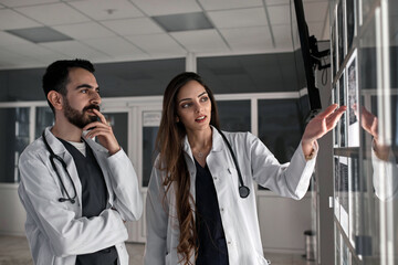A group of surgeon interns is studying fetal development at different stages of pregnancy. Health education concept. Medical students in the classroom with images of ultrasound