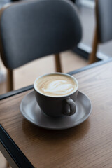 Coffee in cup on wooden table in cafe with lighting background