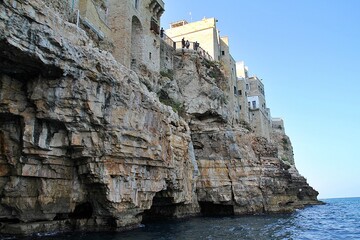  rocky coast, plateau falling into the sea, Polignano a Mare, houses built on the coast, blocks of rock, Puglia region in Italy