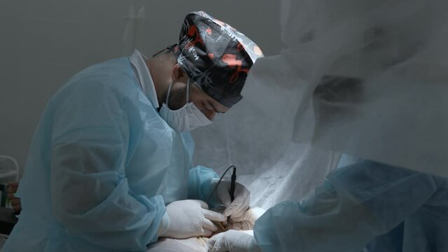 Team of doctors and surgeons processing surgical operation in operating room. Action. Modern hospital emergency department.