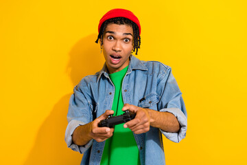Photo of excited positive man wear stylish jeans shirt playstation game enjoy weekend free time isolated on bright yellow color background