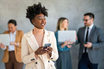Portrait of successful business woman, entrepreneur while multiethnic colleagues working background.