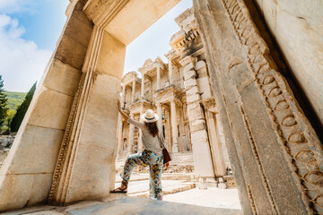 A tourist (woman) sightseeing the ancient city of Ephesus in Turkey; Celsus Library in the background.