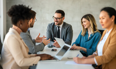 Multicultural professional businesspeople working together on research plan in boardroom.