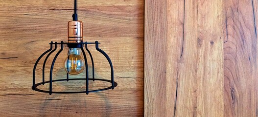 Wooden wall with shining lamp on top. Background texture. Lamp on a background of wooden panels.