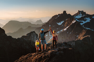 Travel family hiking in Norway climbing mountains expedition active vacations parents and child on summit adventure healthy lifestyle outdoor together mother and father with kid exploring Kvaloya - obrazy, fototapety, plakaty