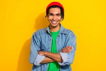 Photo of cool confident man wear jeans shirt red hat smiling arms crossed isolated yellow color background