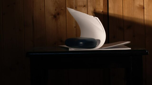 Office desk fan blowing notepad paper