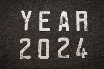 Bonne année 2024 : Concept de nouvelle année 2024 sur le sable noir d'une plage et les chiffres...