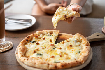 woman holding Pizza quattro fromaggi on a wooden board. Four Cheese Pizza or Quattro Formaggi Pizza...