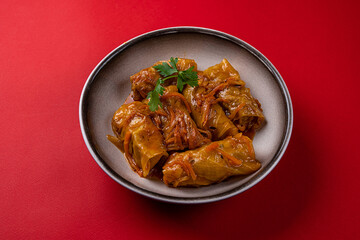 Cabbage Rolls, Stuffed with Meat. On a Red Background, in a Gray Plate.