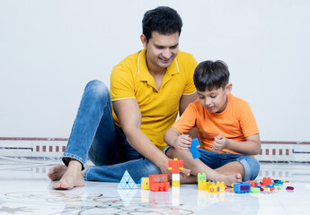 Indian father and son Having fun playing together sitting on floor,Family concept