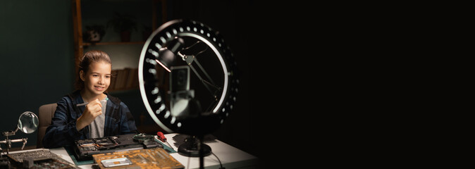 Girl blogger makes online streaming using smartphone is studying electronics and repair circuit boards in his science project at home.